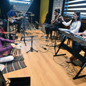 Group of young Musical fusion band rehearsing for performance